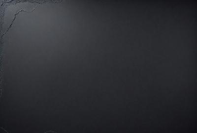 The primary subject of the image is a black background. The setting is a dark room, and the visual style is a black and white photo. The colors and mood are dark and moody, creating a sense of mystery or drama.