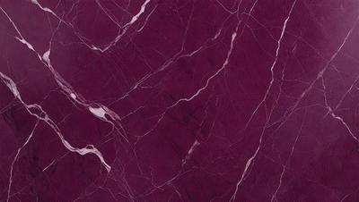 The primary subject of the image is a marble wall with a purple hue. The setting is a room with a purple background, and the visual style is a close-up of the marble wall. The colors and mood of the image are predominantly purple, creating a calm and elegant atmosphere.
