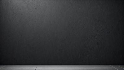 The primary subject of the image is a black wall. The setting is a concrete surface, and the visual style is a photo. The black wall and concrete surface create a dark and moody atmosphere.