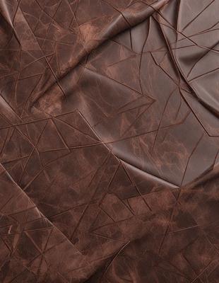 The primary subject of the image is a piece of brown leather, which is the main object, scene, or focus of the image. The setting/background features a leather surface, which is the environment, backdrop, or surface visible in the image. The visual style of the image is a photo, as it is a real-life representation of the leather material. The colors and mood of the image are dominated by the brown leather, giving it a natural and earthy appearance.