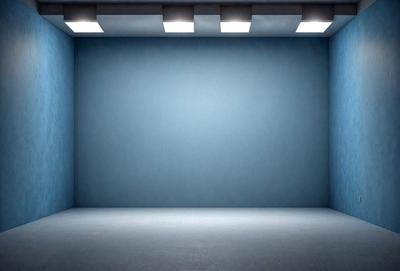 The primary subject of the image is a large, empty room with a blue wall. The setting is a white room with a blue wall, and the visual style is a photo. The colors and mood of the image are predominantly blue, creating a calm and serene atmosphere.
