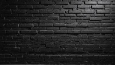 The primary subject of the image is a black brick wall. The setting is a dark room, and the visual style is a black and white photo. The dominant colors are black and white, creating a moody atmosphere.
