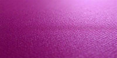 The primary subject of the image is a close-up of a purple surface, which appears to be a piece of fabric or a wall. The setting is indoors, and the visual style is a close-up, which emphasizes the texture and color of the purple surface. The colors and mood of the image are predominantly purple, creating a calm and soothing atmosphere.