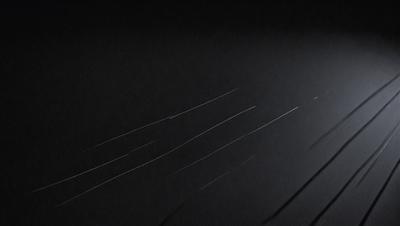 The primary subject of the image is a black background with a white streak or line. The setting is a dark room, and the visual style appears to be a drawing or illustration. The colors are predominantly black and white, creating a stark and dramatic atmosphere.