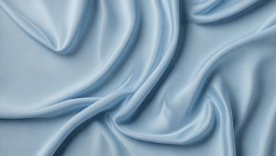 The primary subject of the image is a blue fabric, which appears to be a piece of silk. The setting is a blue background, which complements the blue fabric. The visual style is a close-up of the fabric, showcasing its texture and details. The colors and mood of the image are predominantly blue, creating a calm and serene atmosphere.