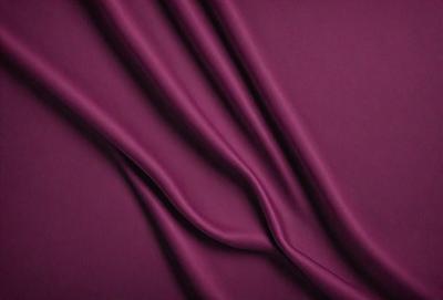 The primary subject of the image is a purple fabric, which is the main object, scene, or focus of the image. The setting or background is a dark purple surface, and the visual style is a close-up of the fabric. The colors and mood of the image are predominantly purple, creating a calm and serene atmosphere.