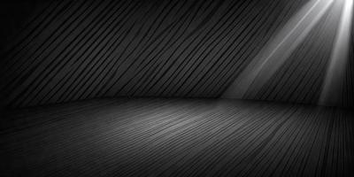 The primary subject of the image is a wooden floor with a black background. The setting appears to be a dark room, possibly a theater or a room with a black curtain. The visual style of the image is a black and white photo, which adds a sense of drama and contrast to the scene. The colors and mood of the image are predominantly dark, with the wooden floor and black background creating a moody atmosphere.