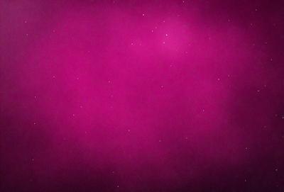The primary subject of the image is a pink background with a purple hue. The setting is a dark, cloudy sky, creating a moody atmosphere. The visual style is a combination of a photo and digital art, as the background appears to be a blend of the two. The colors and mood of the image are predominantly dark and dramatic, with the pink and purple tones adding a sense of warmth and contrast to the overall scene.