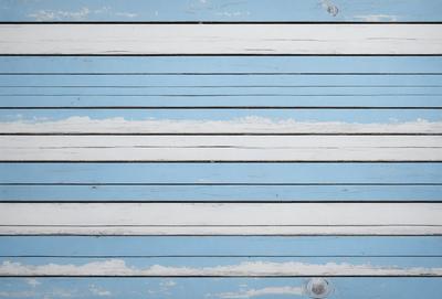 The primary subject of the image is a wooden board with a blue and white striped pattern. The setting is a wooden surface, and the visual style appears to be a combination of a photo and a drawing. The colors and mood of the image are predominantly blue and white, creating a calm and serene atmosphere.
