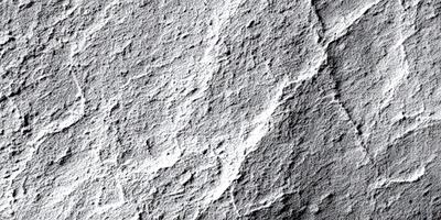 The image features a white rock wall with a pattern of holes and grooves. The primary subject is the rock wall, which is the setting and background of the image. The visual style is a close-up of the rock wall, showcasing its unique texture and pattern. The colors and mood of the image are predominantly white, giving it a clean and minimalist appearance.