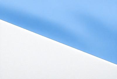 The primary subject of the image is a blue cloth, which is the main object, scene, or focus of the image. The setting or background is a white wall, and the visual style is a photo. The dominant colors are blue and white, creating a calm and serene atmosphere.