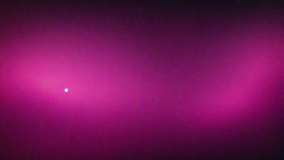 The primary subject of the image is a pink background, which creates a vibrant and lively atmosphere. The setting is a dark room, with the pink background being the main focus. The visual style of the image is a close-up of the pink background, which emphasizes its vivid color. The colors and mood of the image are predominantly pink, giving it a warm and inviting feel.