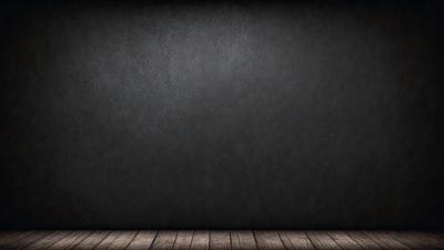 The primary subject of the image is a large, empty, and dark room with a wooden floor. The setting is a black wall, which serves as the background. The visual style is a photo, capturing the room's atmosphere. The colors in the image are predominantly black, creating a moody and mysterious ambiance.