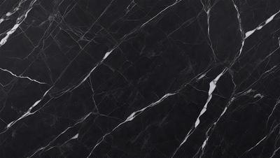 The primary subject of the image is a black marble countertop. The setting is a kitchen, with the countertop being the main focus of the scene. The visual style is a close-up of the marble countertop, showcasing its texture and pattern. The colors and mood of the image are predominantly dark, with the black marble countertop being the main source of contrast.