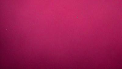 The primary subject of the image is a large, pink surface. The setting is a pink background, and the visual style is a close-up of the pink surface. The colors and mood of the image are predominantly pink, creating a warm and inviting atmosphere.