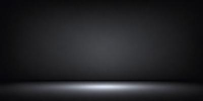 The primary subject of the image is a black background with a white light source. The setting is a dark room, and the visual style is a black and white photo. The dominant colors are black and white, creating a moody atmosphere.
