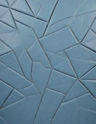 The primary subject of the image is a blue tile with a pattern of triangles. The setting is a wall, and the visual style is a close-up of the tile. The dominant colors are blue and white, creating a calm and soothing atmosphere.