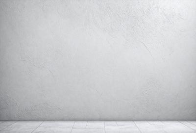 The primary subject of the image is a white wall with a grey texture. The setting is a room with a concrete floor. The visual style is a photo, and the colors and mood are predominantly white and neutral.