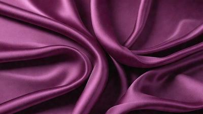 The primary subject of the image is a purple fabric, which is the main object, scene, or focus of the image. The setting or background is a dark surface, and the visual style is a close-up of the purple fabric. The colors and mood of the image are predominantly purple, creating a calm and serene atmosphere.