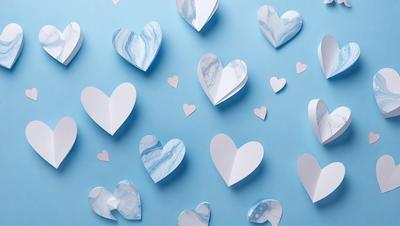 The primary subject of the image is a collection of white paper hearts. These hearts are arranged in various positions and orientations, creating a visually appealing and artistic display. The setting is a blue wall, which serves as a striking backdrop for the hearts. The visual style of the image is a combination of digital art and illustration, as the hearts are created using paper and then digitally arranged on the wall. The colors and mood of the image are predominantly white and blue, giving it a clean, fresh, and