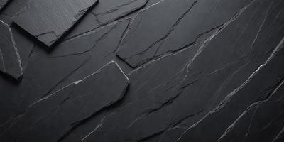 The primary subject of the image is a close-up of a black stone wall. The setting is a dark room, and the visual style is a black and white photo. The dominant colors are black and white, creating a moody atmosphere.