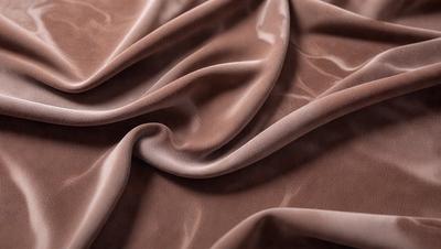 The primary subject of the image is a piece of brown fabric, possibly a piece of leather or a similar material. The setting is a close-up view of the fabric, showcasing its texture and details. The visual style is a realistic representation of the fabric, with no indication of digital manipulation or artistic alterations. The colors and mood of the image are predominantly brown, giving it a warm and natural appearance.
