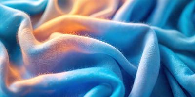 The primary subject of the image is a blue fabric with a texture that resembles a blue and white checkered pattern. The setting is a close-up of the fabric, showcasing its unique texture. The visual style is a close-up of the fabric, which gives a sense of detail and texture. The colors and mood of the image are predominantly blue, creating a calm and soothing atmosphere.
