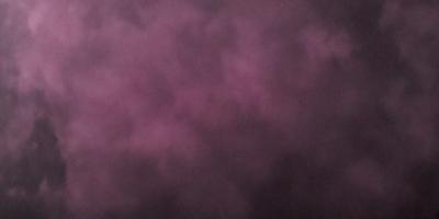 The primary subject of the image is a purple background with a cloudy sky. The setting is a dark, cloudy sky, and the visual style is a photo. The dominant colors are purple and gray, creating a moody atmosphere.