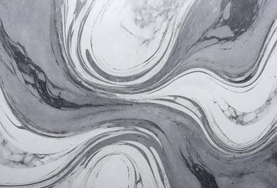 The primary subject of the image is a marble countertop with a patterned design. The setting is a kitchen or bathroom, as the countertop is a part of the counter. The visual style is a close-up of the marble countertop, showcasing its intricate pattern. The colors and mood of the image are predominantly gray, giving it a sophisticated and elegant appearance.