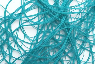 The primary subject of the image is a blue, curly, and twisted piece of yarn. The setting is a white background, which provides a clean and uncluttered environment for the yarn to be the main focus. The visual style is a close-up of the yarn, showcasing its texture and details. The colors and mood of the image are predominantly blue, creating a calm and soothing atmosphere.