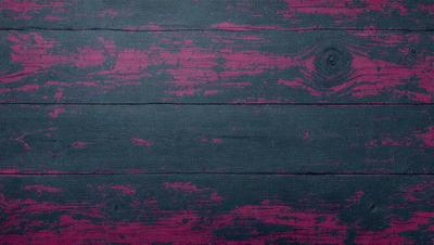 The primary subject of the image is a wooden surface with a purple hue. The setting is a room with a wooden floor, and the visual style appears to be a photo. The dominant colors are purple and blue, creating a calm and serene atmosphere.