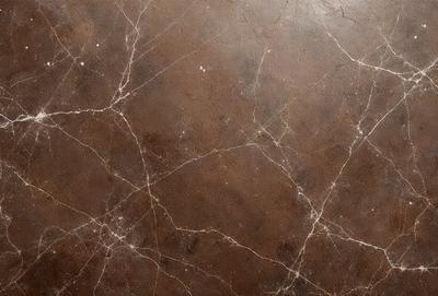 The primary subject of the image is a brown marble wall with a textured surface. The setting is a room with a brown marble floor. The visual style is a close-up of the marble wall, showcasing its unique texture and color. The colors and mood of the image are warm and earthy, with the brown marble creating a natural and luxurious atmosphere.