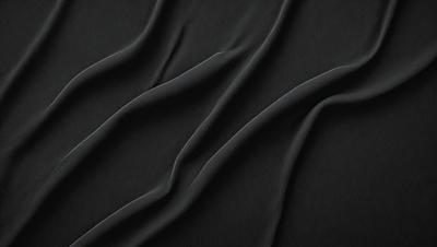 The primary subject of the image is a black fabric with a pattern of wrinkles. The setting is a dark background, and the visual style appears to be a close-up of the fabric. The colors and mood of the image are predominantly dark, with the black fabric being the main focus.