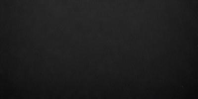 The primary subject of the image is a black leather surface. The setting is a black background, which creates a striking contrast with the leather. The visual style is a close-up of the leather, emphasizing its texture and details. The colors and mood of the image are predominantly dark, with the black leather and background creating a moody and dramatic atmosphere.