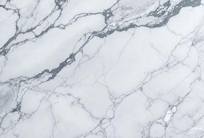 The primary subject of the image is a marble countertop with a white marble finish. The setting is a kitchen, and the visual style is a close-up of the marble countertop. The colors and mood of the image are predominantly white, giving it a clean and elegant appearance.