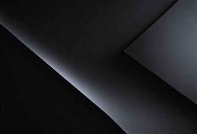 The primary subject of the image is a black wall with a white outline. The setting is a dark room, and the visual style is a black and white photo. The dominant colors are black and white, creating a moody atmosphere.