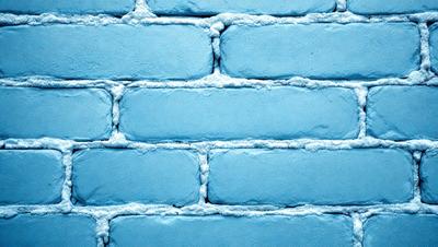 The primary subject of the image is a blue brick wall. The setting is a brick wall, and the visual style is a photo. The dominant colors are blue and white, creating a calm and serene atmosphere.