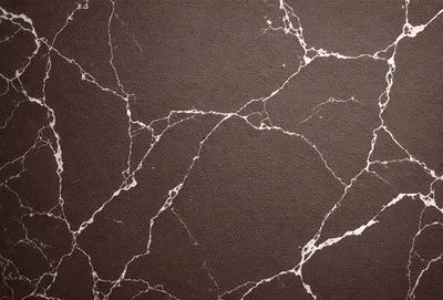 The primary subject of the image is a marble wall with a brown and white pattern. The setting is a room with a brown and white marble wall as the main focus. The visual style is a close-up of the marble wall, showcasing its intricate pattern. The colors and mood of the image are warm and earthy, with the brown and white marble creating a natural and elegant atmosphere.