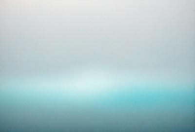 The primary subject of the image is a large body of water, which appears to be a vast ocean. The setting is a cloudy sky, creating a moody atmosphere. The visual style is a photo, capturing the beauty of the ocean and the sky. The dominant colors are blue and gray, reflecting the moodiness of the scene.