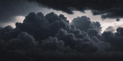 The primary subject of the image is a cloudy sky with dark clouds. The setting is a dark, cloudy sky, and the visual style is a photo. The colors and mood of the image are dark and moody, with the clouds creating a dramatic atmosphere.