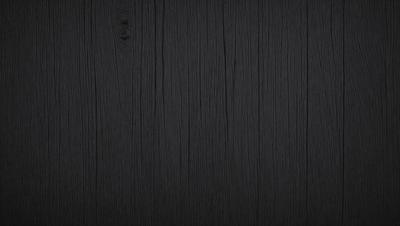 The primary subject of the image is a wooden wall. The setting is a dark room, and the visual style is a close-up of the wooden wall. The colors and mood of the image are predominantly dark, with the wooden wall being the main focus.