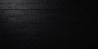 The primary subject of the image is a black wall with a wooden texture. The setting is a dark room, and the visual style is a close-up of the wall. The colors and mood of the image are predominantly dark and moody, with the black wall and wooden texture creating a dramatic and intense atmosphere.