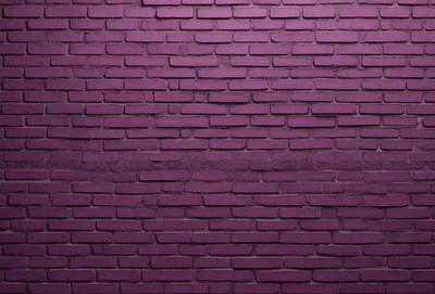 The primary subject of the image is a purple brick wall. The setting is a brick wall, and the visual style is a photo. The dominant colors are purple and pink, creating a warm and inviting atmosphere.