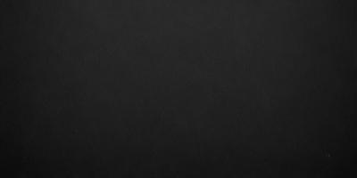The primary subject of the image is a black background. The setting is a dark room, and the visual style is a black and white photo. The colors and mood of the image are dark and moody, creating a sense of mystery or drama.