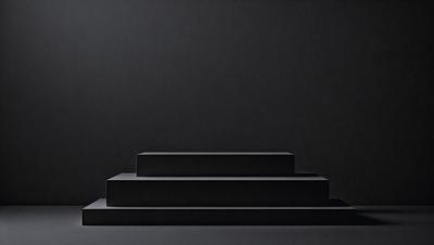 The primary subject of the image is a set of three black steps. The setting is a dark room, with the steps being the main focus of the image. The visual style is a black and white photo, giving the image a classic and timeless appearance. The colors and mood of the image are predominantly dark and moody, with the black steps contrasting against the dark background.