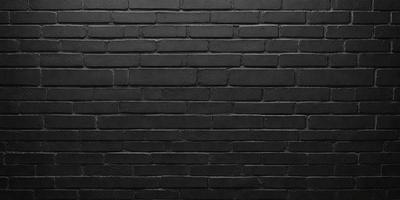 The primary subject of the image is a brick wall. The setting is a black and white photo, which gives the image a classic and timeless appearance. The visual style is a close-up of the brick wall, emphasizing its texture and details. The colors and mood of the image are predominantly black and white, creating a sense of depth and contrast.