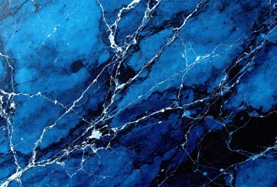 The primary subject of the image is a blue and white marbled surface, which appears to be a wall or a piece of art. The setting is a room with a blue background, and the visual style is a close-up of the marbled surface. The colors and mood of the image are predominantly blue and white, creating a calm and serene atmosphere.