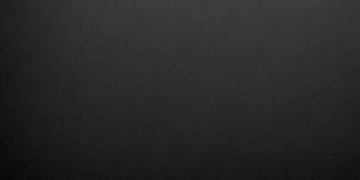 The primary subject of the image is a black background. The setting is a dark room, and the visual style is a black and white photo. The colors and mood of the image are dark and moody, creating a sense of mystery or drama.