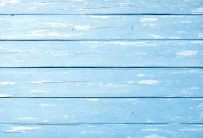 The primary subject of the image is a blue wall with a wooden texture. The setting is a room with a blue wall, and the visual style is a photo. The dominant colors are blue and white, creating a calm and serene atmosphere.
