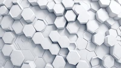 The primary subject of the image is a white wall with a pattern of white hexagons. The setting is a white room, and the visual style is a close-up of the hexagonal pattern. The dominant colors are white, and the overall atmosphere is clean and minimalistic.